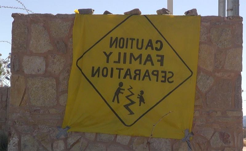 抗议标语上画着一个路标，上面写着“小心家庭分离”。